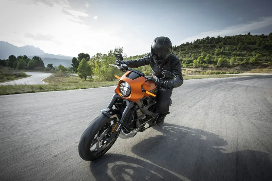 Motorista tumbando en una curva con una moto naranja